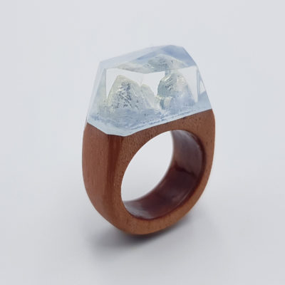 Resin ring in light blue color with wooden base