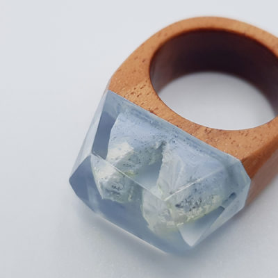 Resin ring in light blue  with wooden base
