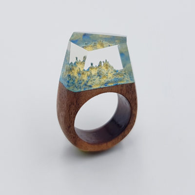 Resin ring in light blue and yellow color with wooden base