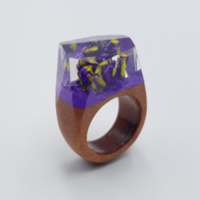 Resin ring in purple and yellow color with wooden base