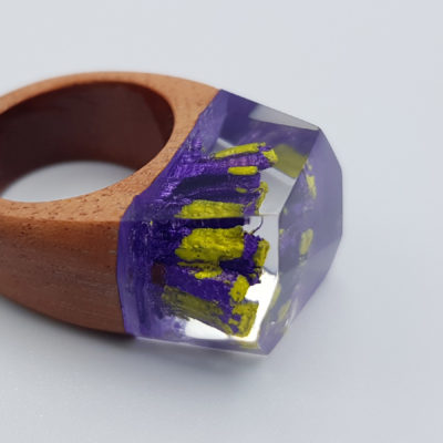 Resin ring in purple and yellow r with wooden base