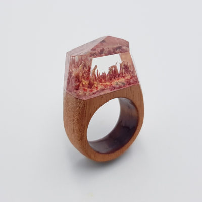 Resin ring in pink and yellow color with wooden base